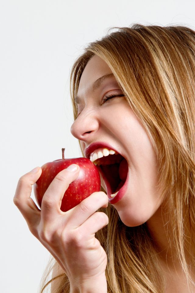 kobieta gryzie jabłko - jak wzmocnić szkliwo